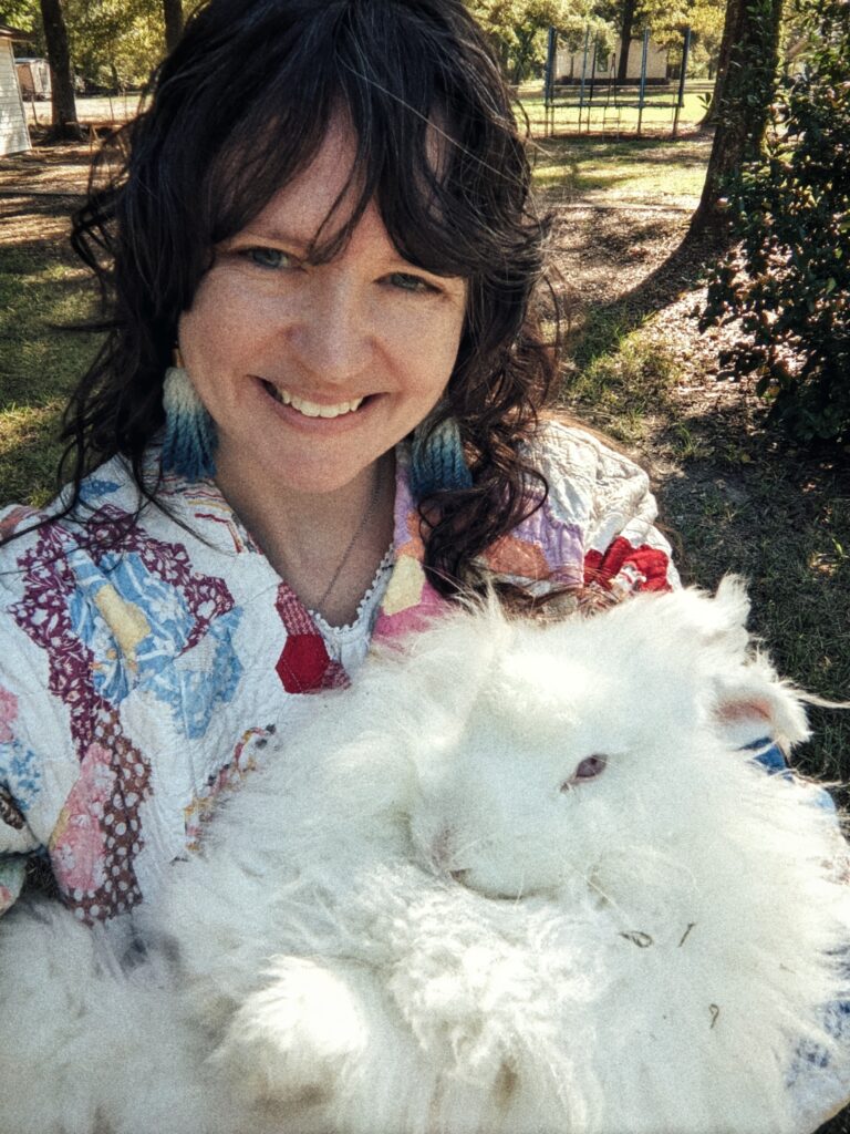 a woman holding an angora rabbit.