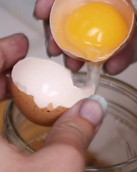 hands separating an egg yolk and white.