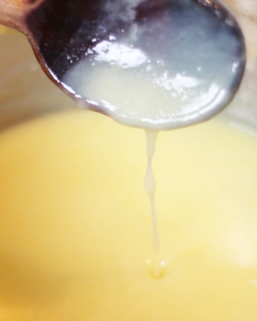 a pot of custard, and a wooden spoon for stirring the custard.