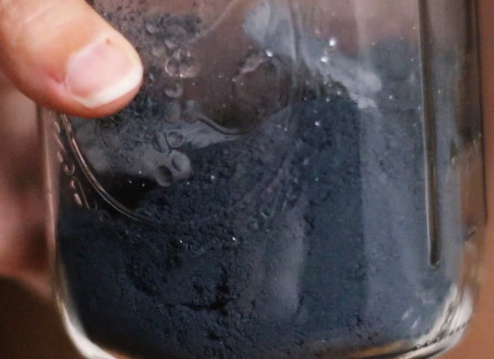 a glass jar about 1/4 full of dried indigo pigment.