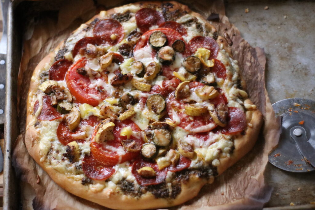 a homemade pizza with pesto sauce