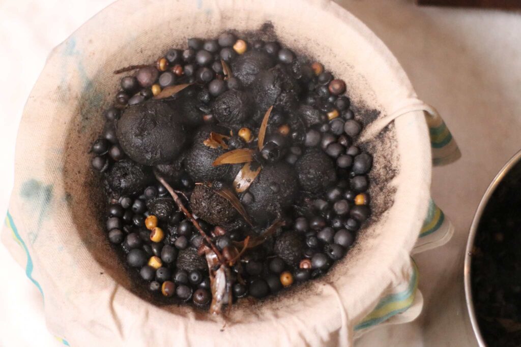 a strainer full of boiled acorns and walnuts