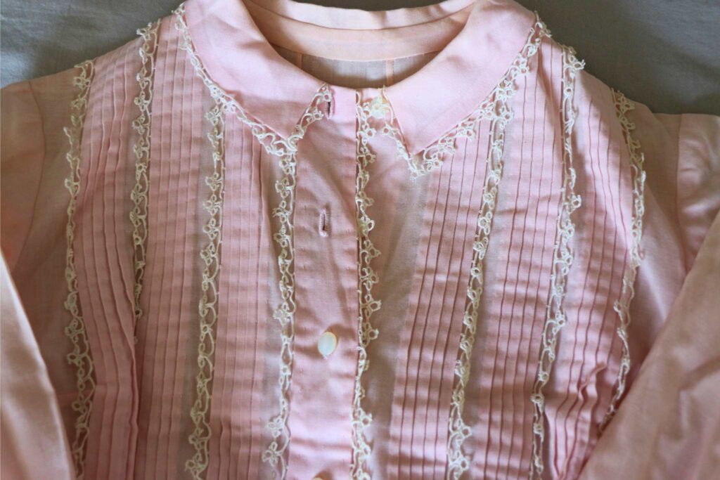 a vintage handmade pink dress with white tatted lace trim