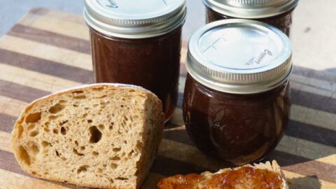 three jars of muscadine jam, and some bread with jam on it