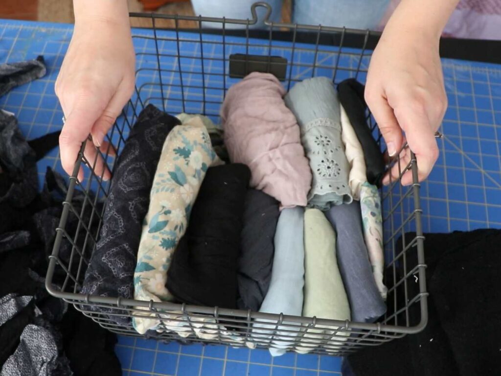 a basket of folded upcycled fabric scraps from old clothes
