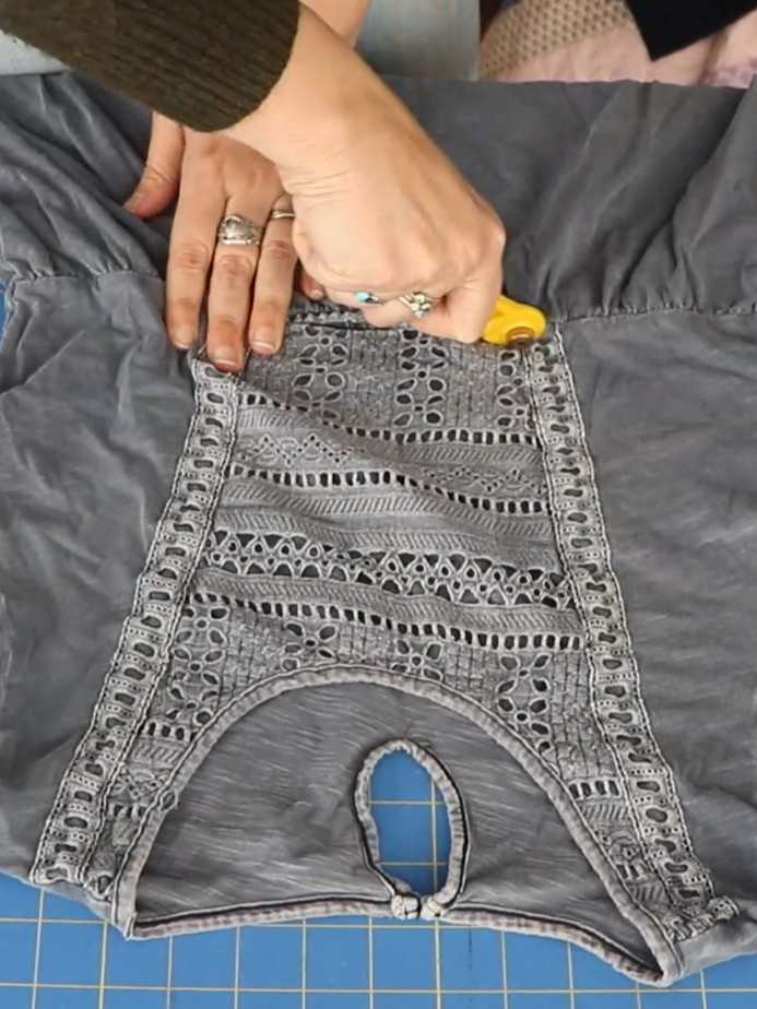 hands cutting up an old t-shirt with a rotary cutter