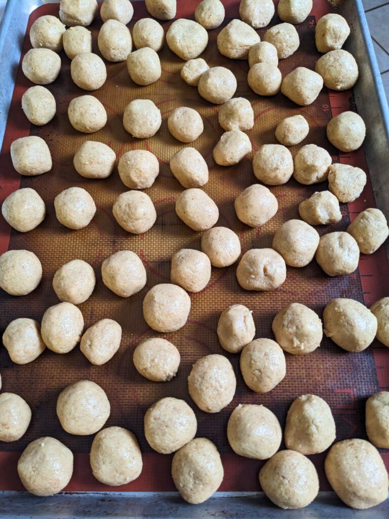 a tray of peanut butter balls, ready to be coated in chocolate.