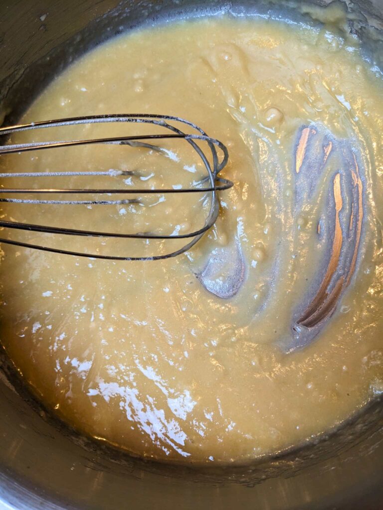 whisking a roux for creamed eggs on toast
