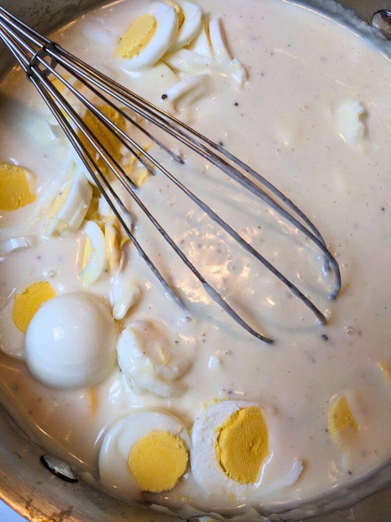 stirring chopped hard boiled eggs into the cream sauce for creamed eggs on toast
