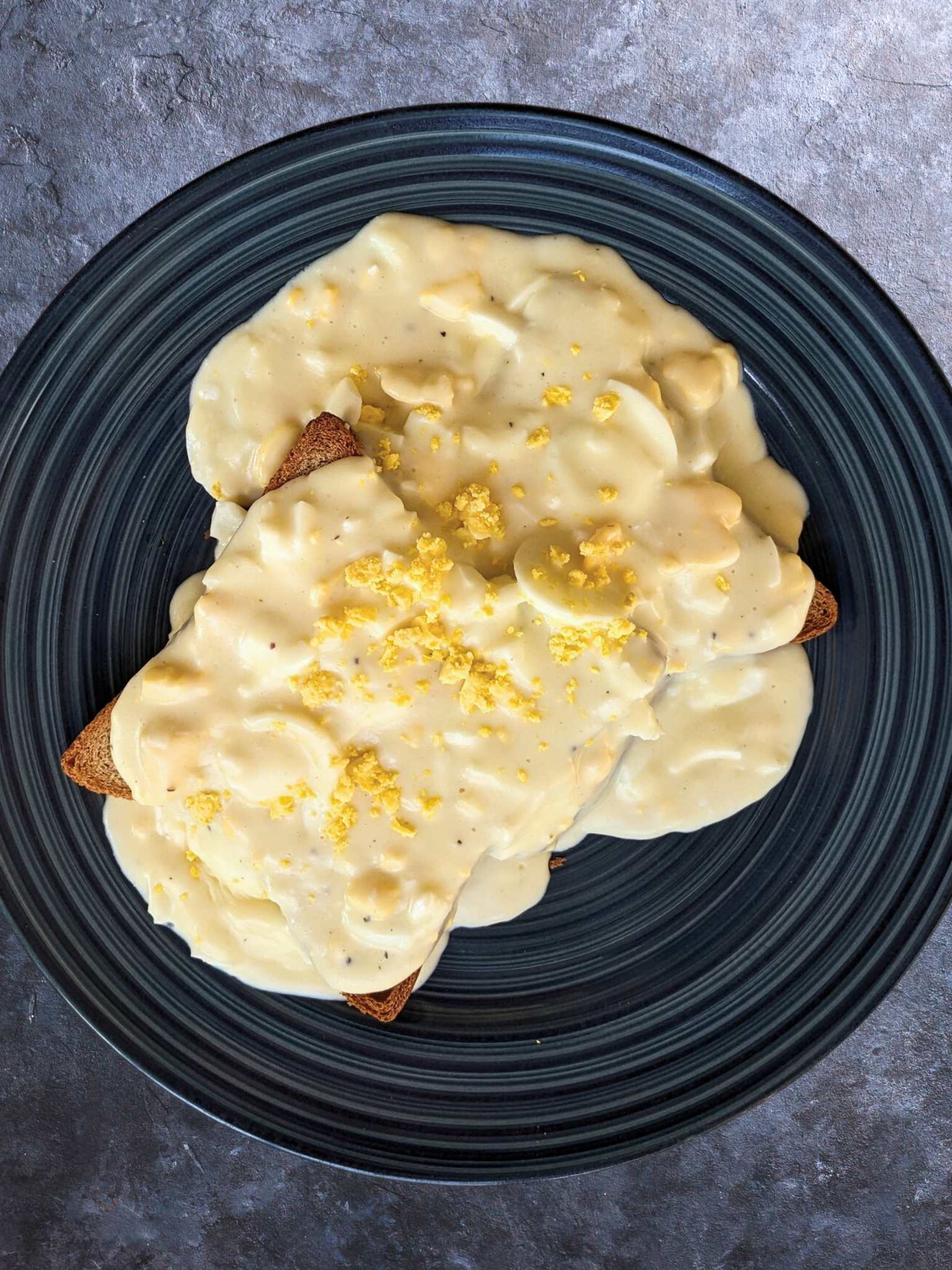 a plate of creamed eggs on toast