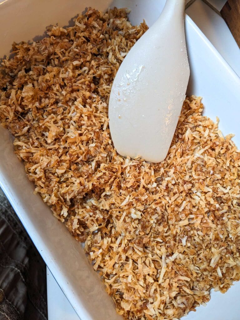 pressing the almond joy filling into a pan