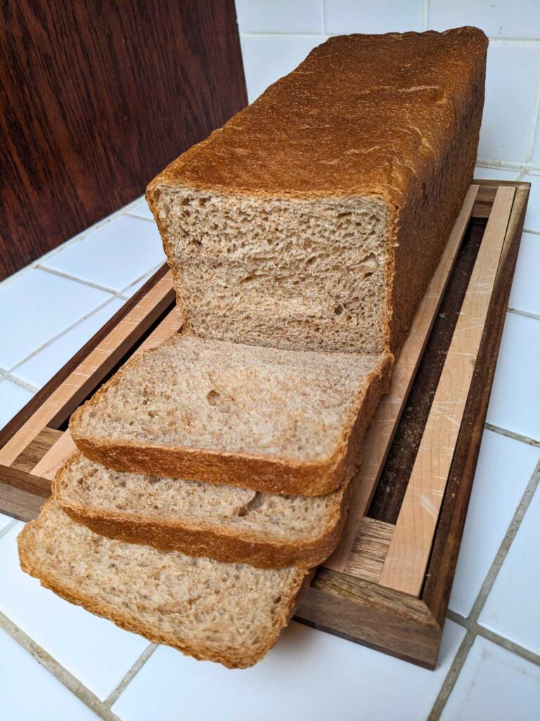 a loaf of whole wheat pain de mie bread, partially sliced.