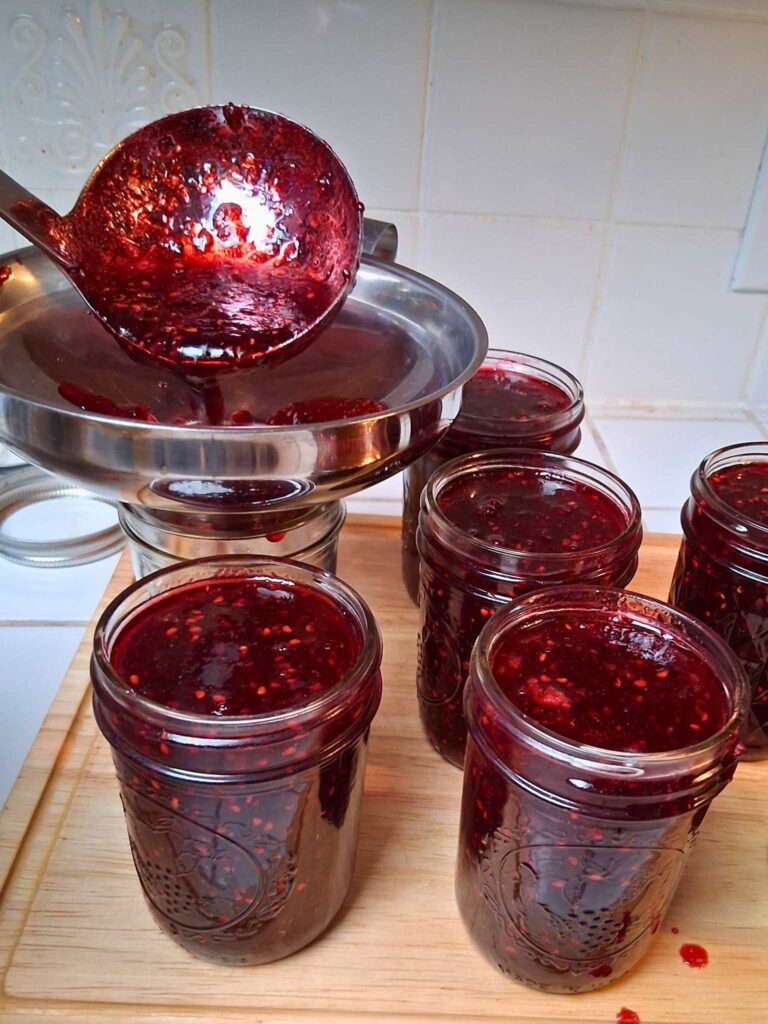 filling blackberry jam jars using a jar funnel